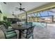 Outdoor dining area on a screened patio overlooking a pool and a peaceful waterfront view at 3360 Hickorywood Way, Tarpon Springs, FL 34688