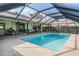 Beautiful screened-in pool area with plenty of seating and a picturesque view of the backyard and waterfront at 3360 Hickorywood Way, Tarpon Springs, FL 34688