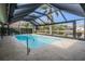 Sparkling pool enclosed by a screen cage, offering privacy and a serene waterfront view at 3360 Hickorywood Way, Tarpon Springs, FL 34688