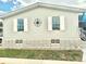 Exterior of a light green mobile home with white shutters at 34612 Pine N Dr, Pinellas Park, FL 33781