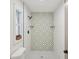 Updated bathroom with patterned tile shower and window at 3911 King Dr, Brandon, FL 33511