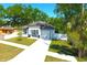 Well-maintained single-story home with a lush lawn, white exterior, and attached garage at 408 E Hanlon St, Tampa, FL 33604