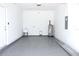 Spacious garage with epoxy floors, utility sink, water heater, and electrical panel at 408 E Hanlon St, Tampa, FL 33604