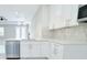New kitchen featuring white cabinets, stainless steel appliances, and marble countertops and backsplash at 408 E Hanlon St, Tampa, FL 33604