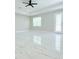 Spacious living room with tiled floors, ceiling fan, and doors to the exterior at 408 E Hanlon St, Tampa, FL 33604