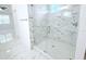 Glass-enclosed shower featuring white and grey marble-patterned tiling and a modern showerhead at 408 E Hanlon St, Tampa, FL 33604