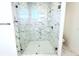 Glass-enclosed shower featuring white and grey marble-patterned tiling and a modern showerhead at 408 E Hanlon St, Tampa, FL 33604