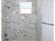 Shower stall featuring white and grey marble-patterned tiling and a shower head at 408 E Hanlon St, Tampa, FL 33604