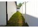 Narrow side yard with green grass and a well-maintained white fence, enhancing privacy and property appeal at 408 E Hanlon St, Tampa, FL 33604