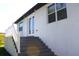 Exterior staircase leading to a balcony, featuring clean lines, crisp white trim, and a smooth concrete finish at 408 E Hanlon St, Tampa, FL 33604