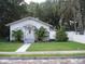 White bungalow home with a sidewalk, lawn, and trees at 420 5Th N St, Safety Harbor, FL 34695