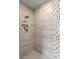 Tiled shower featuring decorative accents and recessed niche offering a spa-like experience at 10639 Ruffino Ct, Trinity, FL 34655