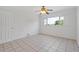Bright bedroom with tile floors, a ceiling fan, and a window with palm tree views at 3717 46Th S Ave # 6, St Petersburg, FL 33711