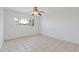 Minimalist bedroom with neutral-toned tile flooring, a ceiling fan, and a sunny window at 3717 46Th S Ave # 6, St Petersburg, FL 33711