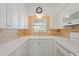 Well-lit kitchen with white cabinets, brick backsplash, and modern appliances at 3717 46Th S Ave # 6, St Petersburg, FL 33711