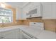Kitchen with white cabinets, white appliances, brick backsplash, and a window at 3717 46Th S Ave # 6, St Petersburg, FL 33711