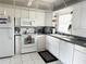 Bright kitchen with white cabinets, appliances, and tiled floor at 4525 Cove Cir # 1002, St Petersburg, FL 33708