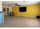 Spacious living room with a ceiling fan, tile floors, and a bright yellow accent wall at 6888 121St N St, Seminole, FL 33772