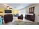 Living room with yellow walls, large TV, comfy seating, and ceiling fan at 6888 121St N St, Seminole, FL 33772