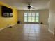 Open living room area featuring tile flooring, large window with shutters, and mounted television at 6888 121St N St, Seminole, FL 33772