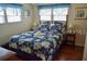 Bright bedroom featuring blue floral bedding, complementing curtains, and hardwood floors at 72 Liberty Way # 4, Palm Harbor, FL 34684