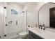 Bathroom with a walk-in shower, gray vanity, and arched mirror at 8611 Quail Hollow Blvd, Wesley Chapel, FL 33544