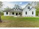 White farmhouse exterior with a wraparound porch and landscaping at 8611 Quail Hollow Blvd, Wesley Chapel, FL 33544