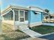 Light blue mobile home with carport, steps, and landscaped lawn at 9790 66Th N St # 330, Pinellas Park, FL 33782