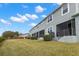 Backyard view of the rear of the property showcasing the screened-in patio and well-maintained lawn at 1003 Starboard Ct, Oldsmar, FL 34677