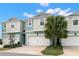 Beautiful townhome with a two-car garage, mature landscaping, and a neatly manicured lawn at 1003 Starboard Ct, Oldsmar, FL 34677
