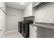 This laundry room features a sleek, modern washer and dryer set with white cabinetry and ample countertop space at 1003 Starboard Ct, Oldsmar, FL 34677