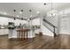 Spacious living room with wood floors, a modern kitchen, and a staircase leading to the upper level at 1003 Starboard Ct, Oldsmar, FL 34677