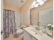 Bathroom with tub, vanity, and floral shower curtain at 1237 Huntington Greens Dr, Sun City Center, FL 33573