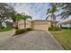 Tan home with three-car garage and palm trees at 1237 Huntington Greens Dr, Sun City Center, FL 33573