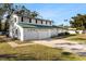 White brick home with green roof, two-car garage, and side yard at 13208 Lake Magdalene Blvd, Tampa, FL 33618