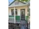 Front view of a small cottage, showcasing its white and green exterior at 2508 50Th N Ave, St Petersburg, FL 33714