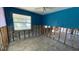 A blue-walled bedroom under renovation, showing exposed framing and flooring at 5641 1St Ne St, St Petersburg, FL 33703