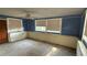 A living room with blue walls and beige wainscoting, needing renovation at 5641 1St Ne St, St Petersburg, FL 33703