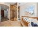 Bathroom featuring glass shower, garden tub with tiled surround, and tiled floors at 6015 Kipps Colony E Dr, Gulfport, FL 33707