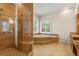 Bathroom featuring a walk-in shower and soaking tub with natural light from several windows at 6015 Kipps Colony E Dr, Gulfport, FL 33707