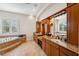 Elegant bathroom featuring a large tub, natural light, vanity and granite counters at 6015 Kipps Colony E Dr, Gulfport, FL 33707