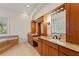 Bathroom with custom cabinetry, double vanity with granite counters, and a soaking tub at 6015 Kipps Colony E Dr, Gulfport, FL 33707