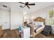 Spacious bedroom boasts hardwood floors, a bed, a ceiling fan, desk and ensuite bath at 6015 Kipps Colony E Dr, Gulfport, FL 33707