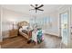 Bedroom with hardwood floors, ceiling fan, a cozy bed, desk, and lots of natural light at 6015 Kipps Colony E Dr, Gulfport, FL 33707