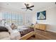 Bedroom featuring hardwood floors, a cozy bed, large windows with shutters, and ceiling fan at 6015 Kipps Colony E Dr, Gulfport, FL 33707