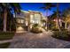 Elegant two-story home with a brick driveway, lush landscaping, and a grand entrance at 6015 Kipps Colony E Dr, Gulfport, FL 33707