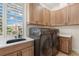 Well-equipped laundry room with modern washer and dryer, custom cabinets, and a window view at 6015 Kipps Colony E Dr, Gulfport, FL 33707