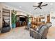 Open-concept living room featuring a media center, tile floors, ceiling fan, and decorative plants at 6015 Kipps Colony E Dr, Gulfport, FL 33707