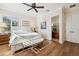 Bright main bedroom boasts hardwood floors, ceiling fan, ensuite bathroom, and natural sunlight at 6015 Kipps Colony E Dr, Gulfport, FL 33707
