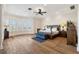 Spacious main bedroom with hardwood floors, bay window, ceiling fan, and serene decor for a comfortable retreat at 6015 Kipps Colony E Dr, Gulfport, FL 33707